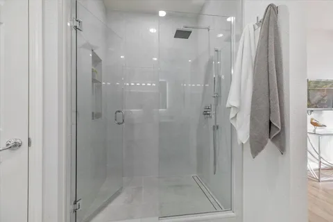 a bathroom with a shower and a glass door