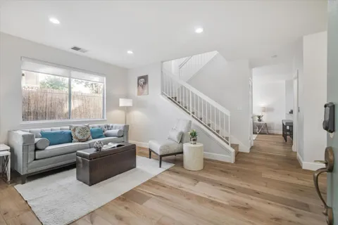 a living room with furniture and wooden floor