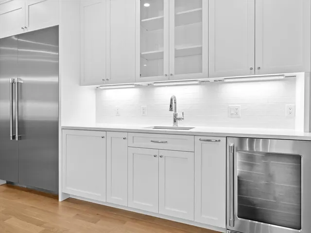 a kitchen with granite countertop white cabinets and a refrigerator