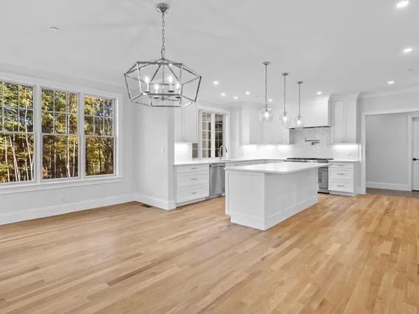 a view of large kitchen with granite countertop stainless steel appliances and cabinets