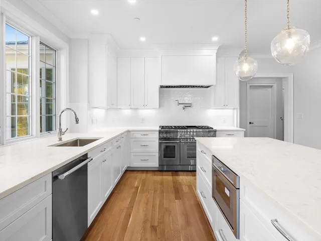 a kitchen with a stove a sink a center island and windows