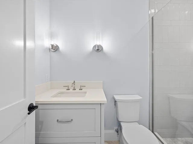 a bathroom with a sink mirror vanity and toilet