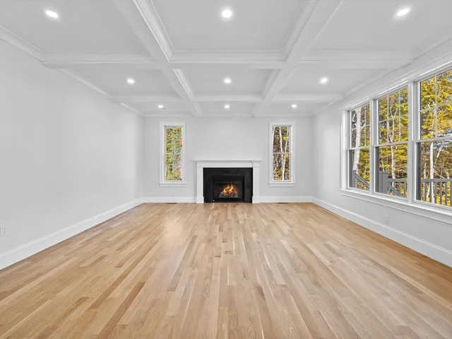 an empty room with windows and fireplace