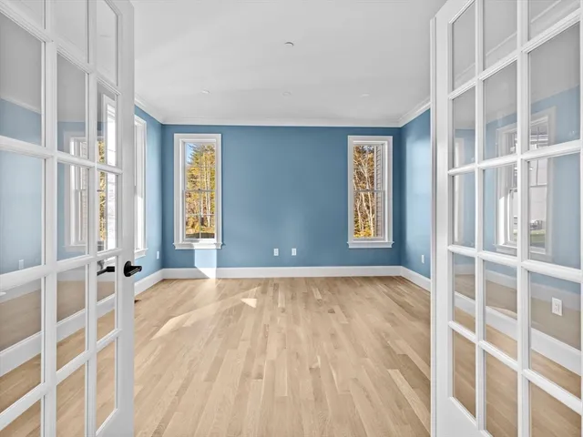 an empty room with wooden floor and windows