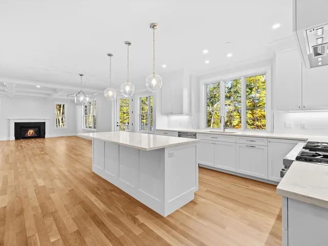 a large kitchen with kitchen island white cabinets and stainless steel appliances