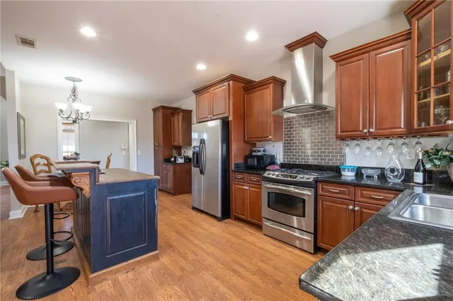 a kitchen with stainless steel appliances granite countertop a stove a sink dishwasher and a refrigerator