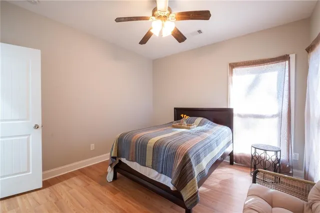 a bedroom with a bed and wooden floor