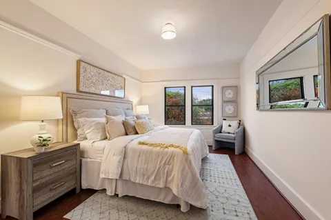 a view of backyard with large trees and wooden fence