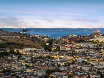 a view of an empty room with window and hardwood floor