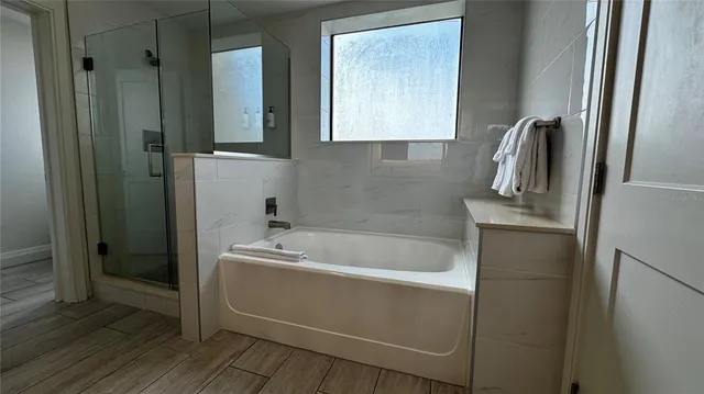 a bathroom with a tub a sink and mirror