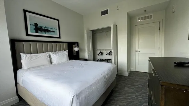 a bedroom with bed and paintings on the wall