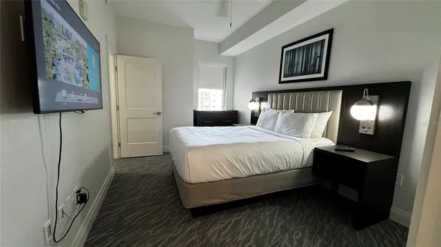 a bedroom with a bed and a painting on the wall