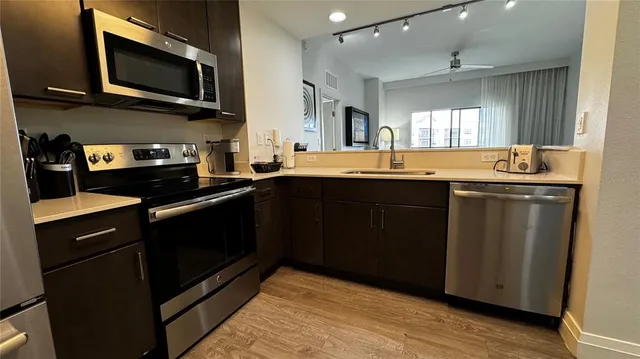 a kitchen with stainless steel appliances granite countertop a sink and a microwave