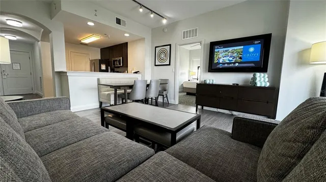 a living room with furniture a rug and kitchen view