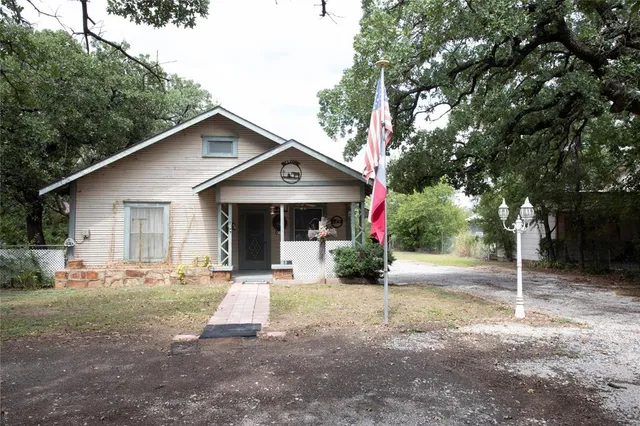 a front view of a house with a yard and tree