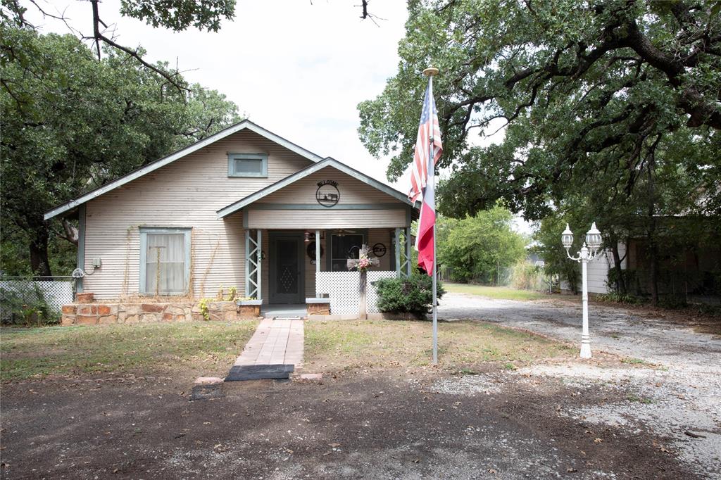 a front view of a house with a yard and tree