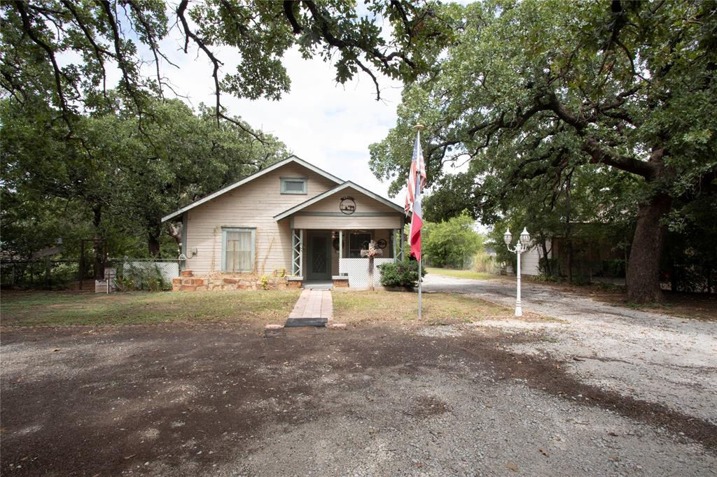 1311 Loving Highway Graham, TX 76450 - Photo 2 of 31 a view of a house with a yard and large trees