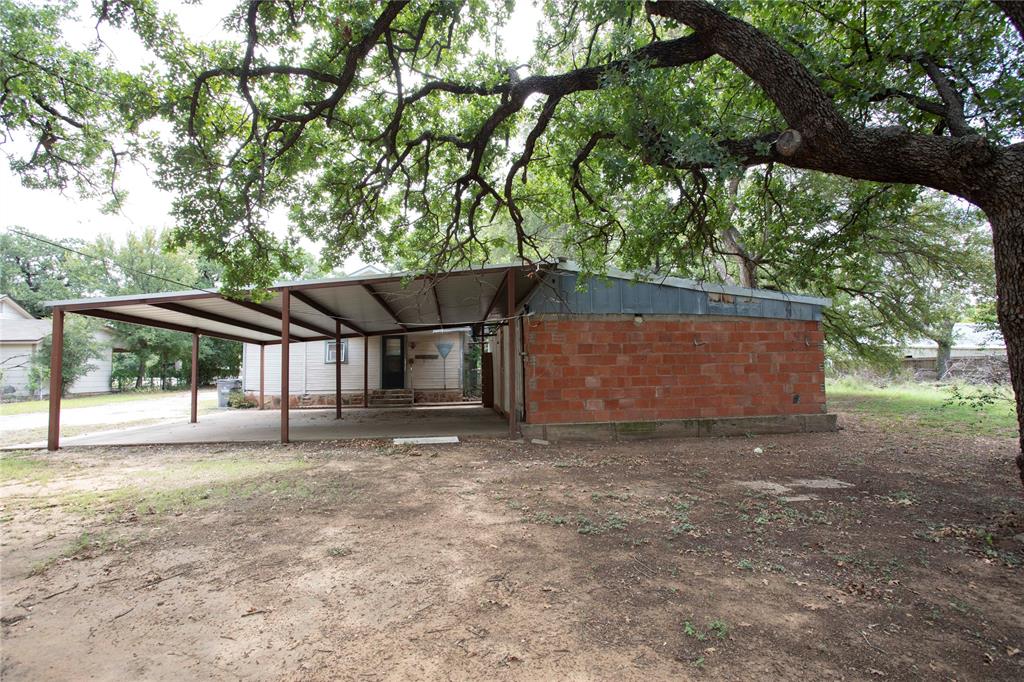 1311 Loving Highway Graham, TX 76450 - Photo 23 of 31 a backyard of a house with table and chairs under an umbrella