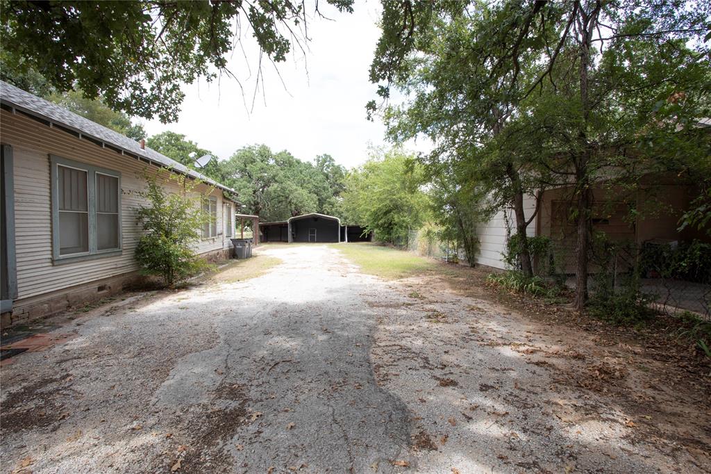 1311 Loving Highway Graham, TX 76450 - Photo 4 of 31 a backyard of a house with large trees and outdoor seating