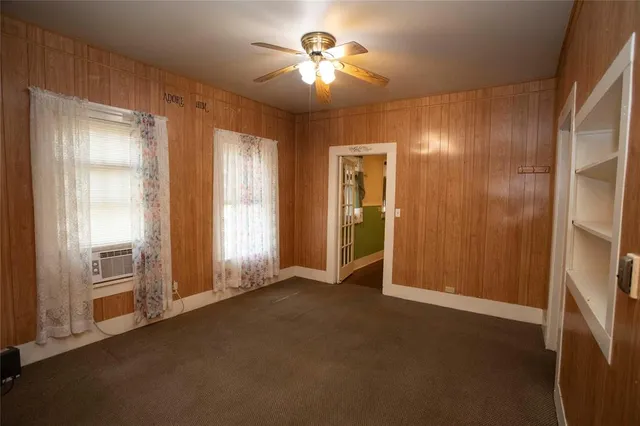an empty room with closet and a chandelier fan