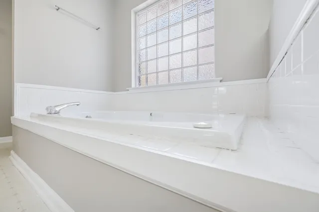 a bathroom with a bathtub and next to a window