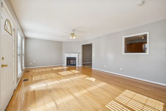 a view of an empty room with a chandelier fan