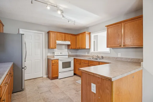 a kitchen with stainless steel appliances granite countertop a sink stove and refrigerator