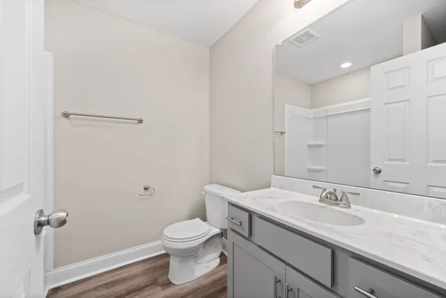 a bathroom with a granite countertop sink a toilet and a mirror