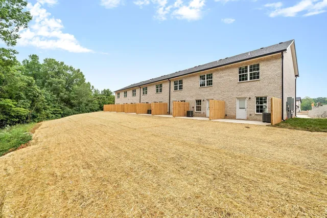 a view of house with yard and trees in the background