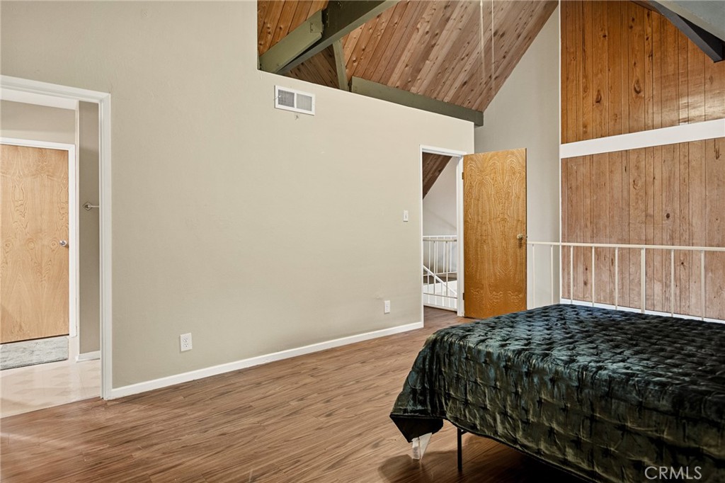 966 Willow Creek Road, Unit 9 Lake Arrowhead, CA 92352 - Photo 13 of 24 a bedroom with a bed and wooden floor