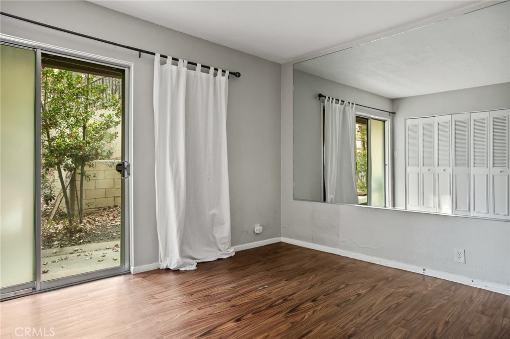 966 Willow Creek Road, Unit 9 Lake Arrowhead, CA 92352 - Photo 17 of 24 an empty room with wooden floor and windows