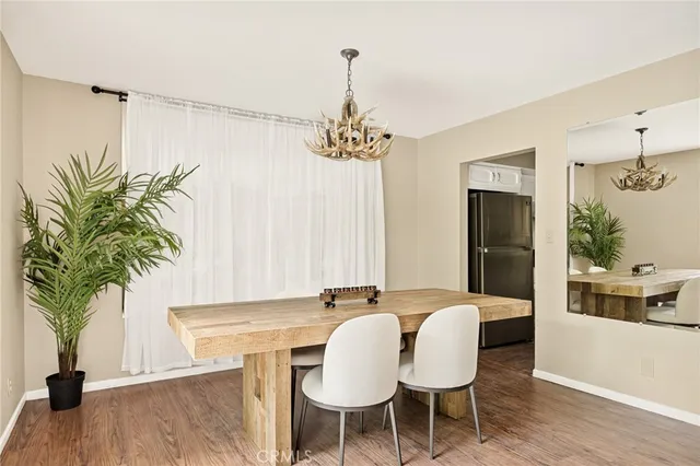 a dining room with furniture potted plants and wooden floor