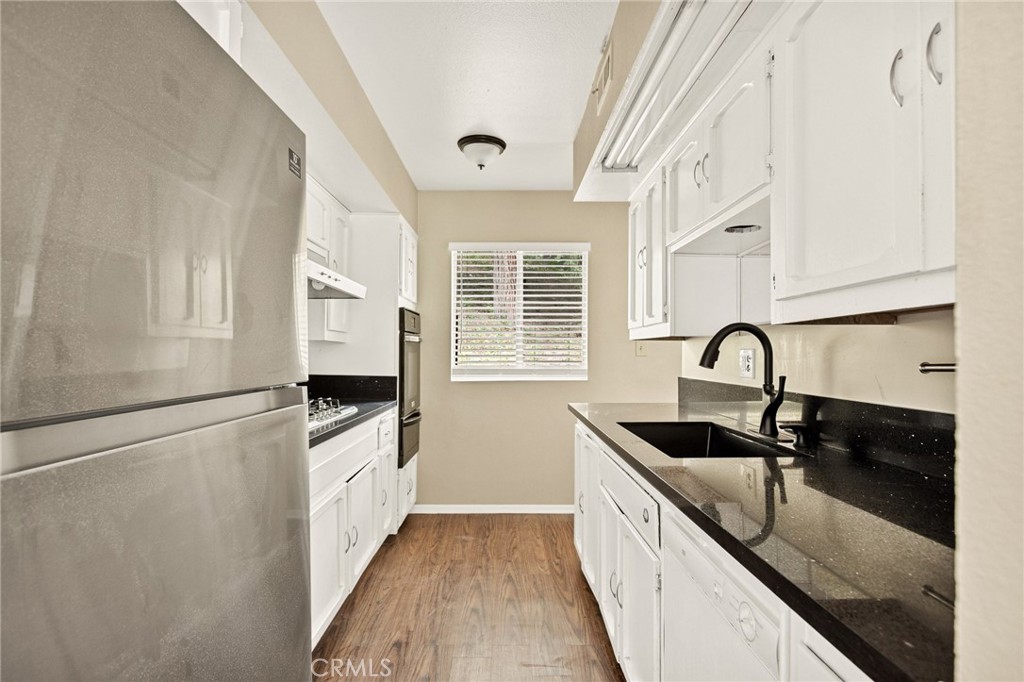 966 Willow Creek Road, Unit 9 Lake Arrowhead, CA 92352 - Photo 6 of 24 a kitchen with granite countertop a sink and wooden cabinets