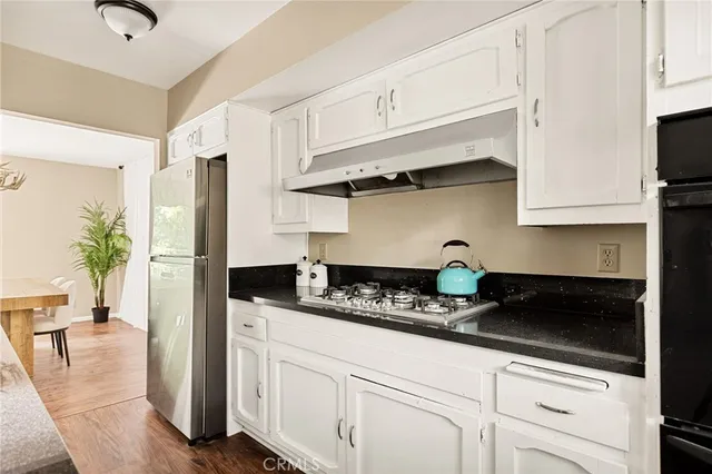 a kitchen with stainless steel appliances granite countertop a sink a stove and a refrigerator