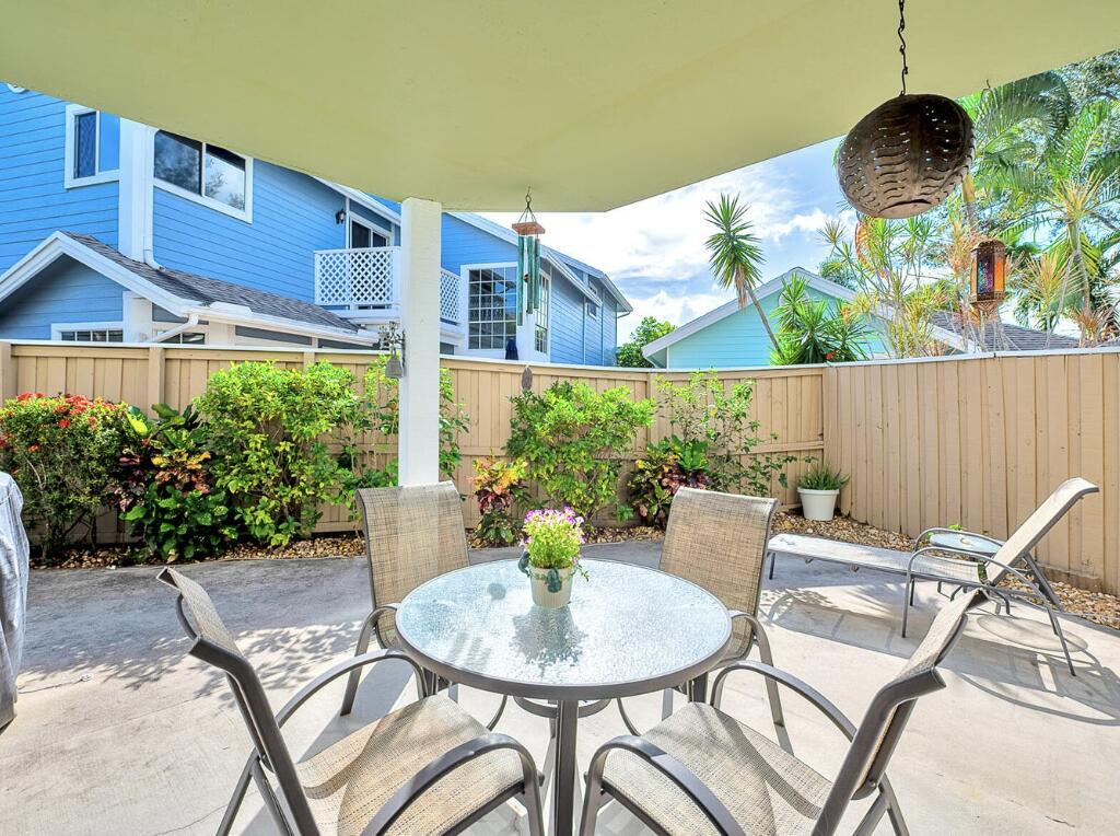 5124 Point Alexis Boca Raton, FL 33431 - Photo 15 of 21 a view of a patio with table and chairs potted plants and wooden fence