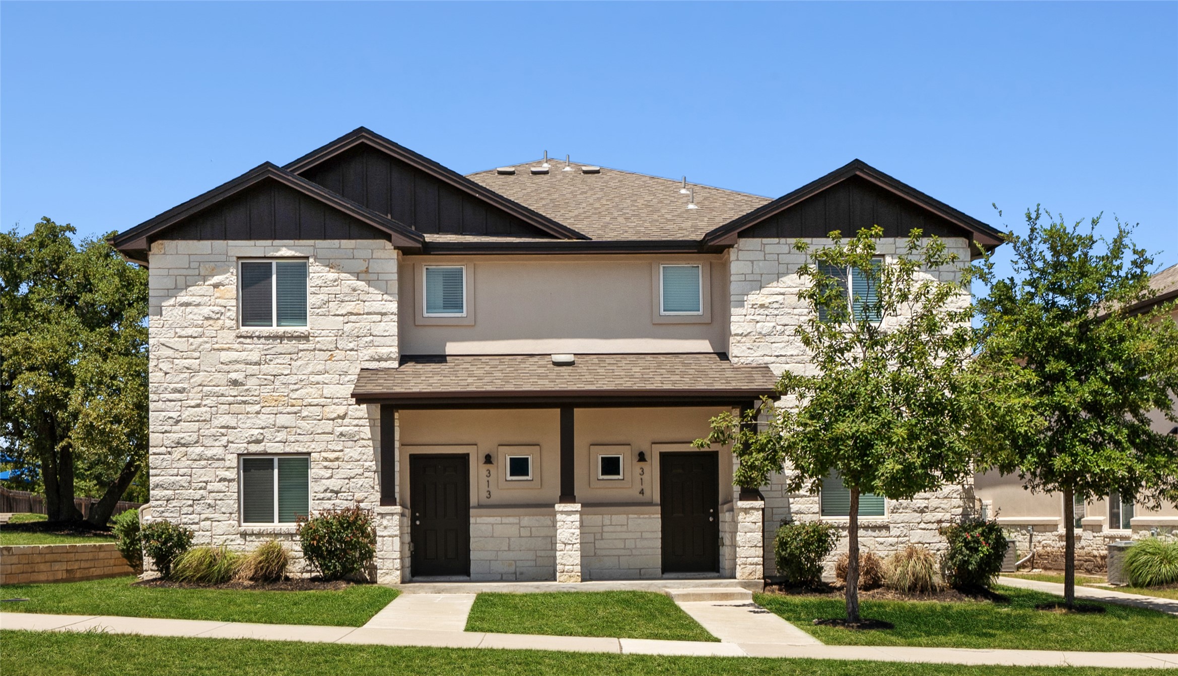 Craftsman house featuring roof with shingles, stone siding, and board and batten siding