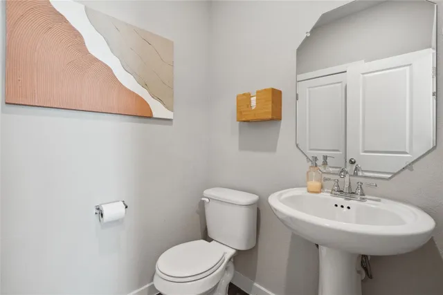 a bathroom with a sink a toilet and mirror