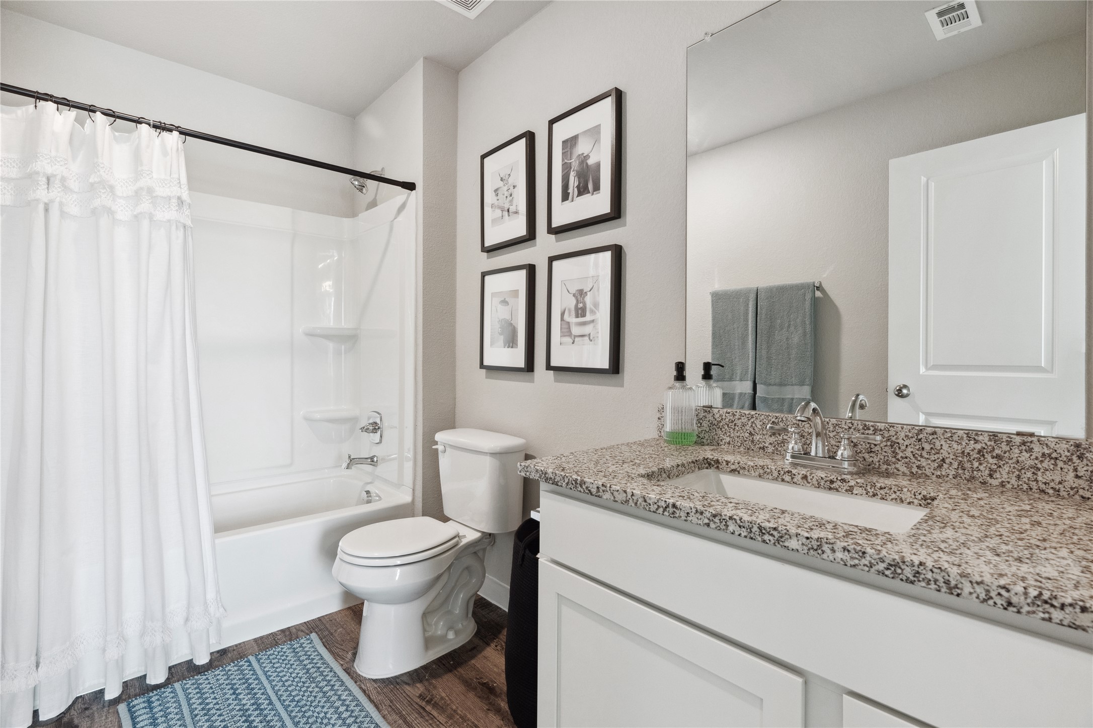 705 Apache Trail, Unit 511 Leander, TX 78641 - Photo 10 of 12 Bathroom with toilet, vanity, shower / bath combo, wood finished floors, and baseboards