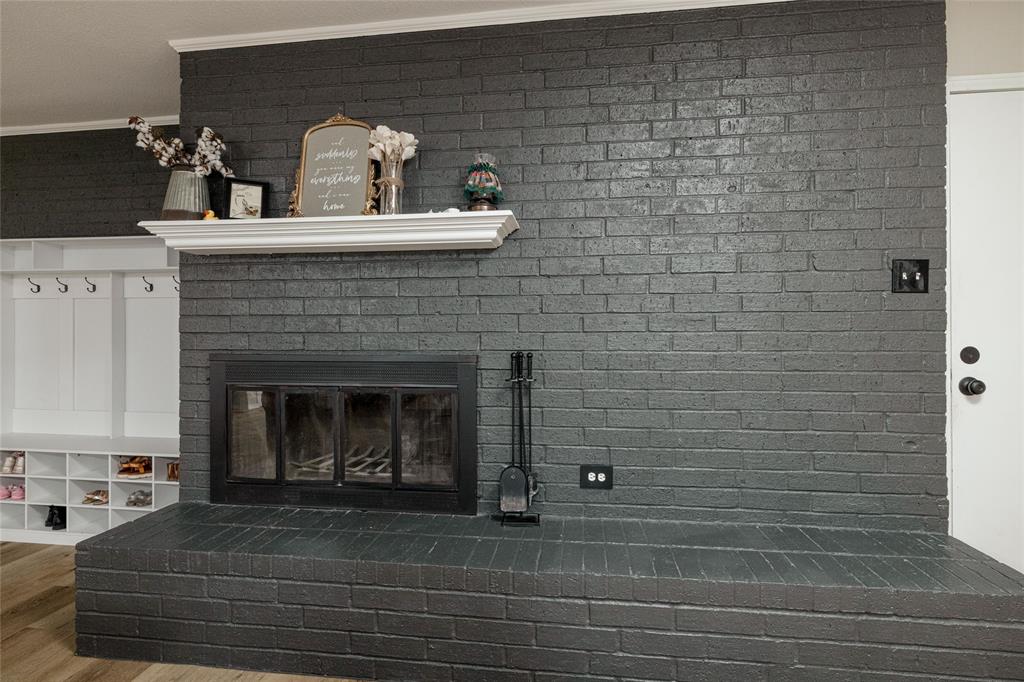 117 Kathryn Street Sanger, TX 76266 - Photo 10 of 40 Detailed view of a brick fireplace, wood finished floors, and crown molding