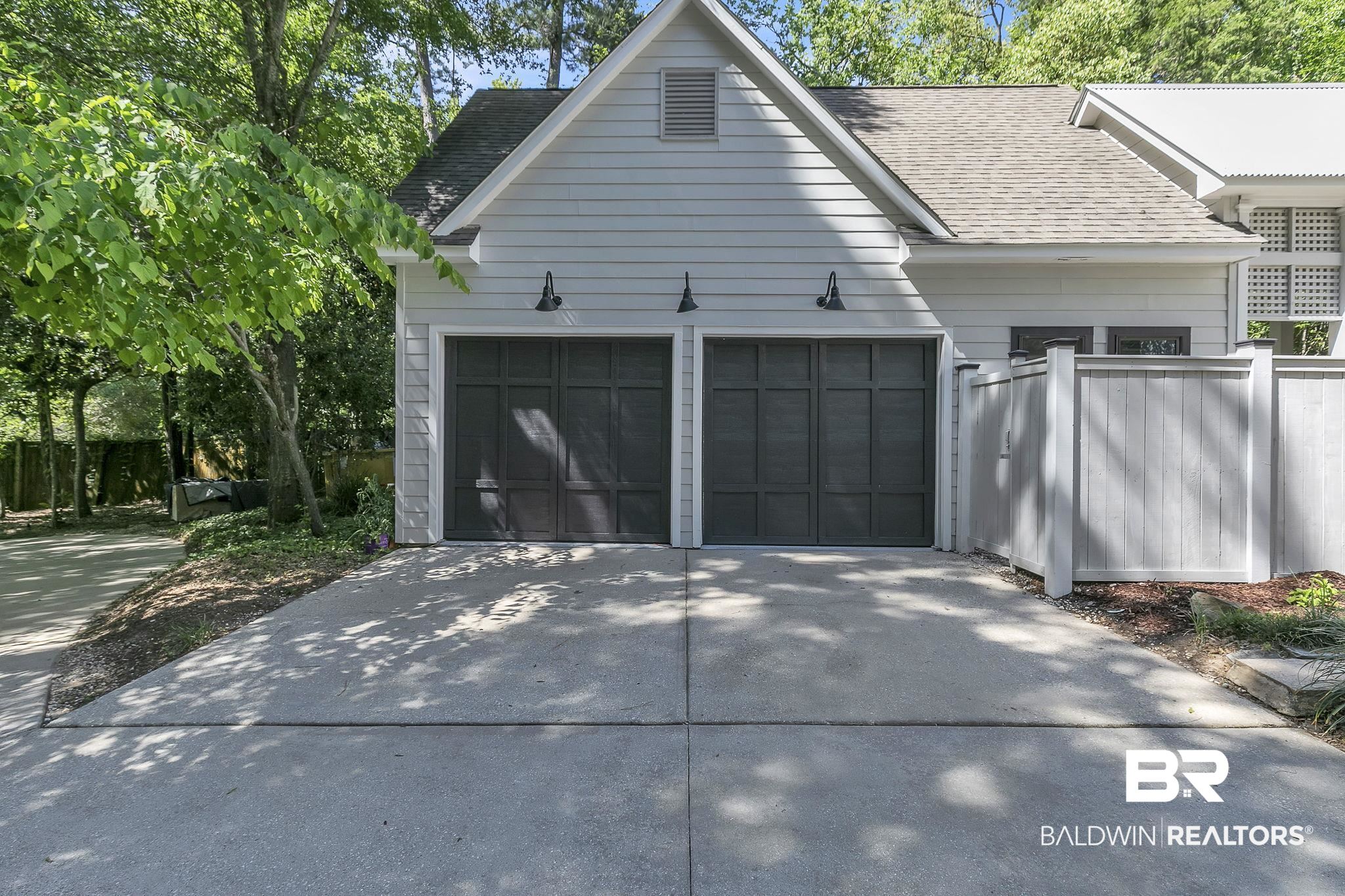 1106 Old County Road Daphne, AL 36526 - Photo 6 of 66 Two-car garage with dark paneled doors and gooseneck lighting