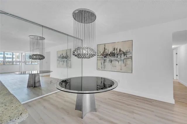 a room with wooden floor table and chairs