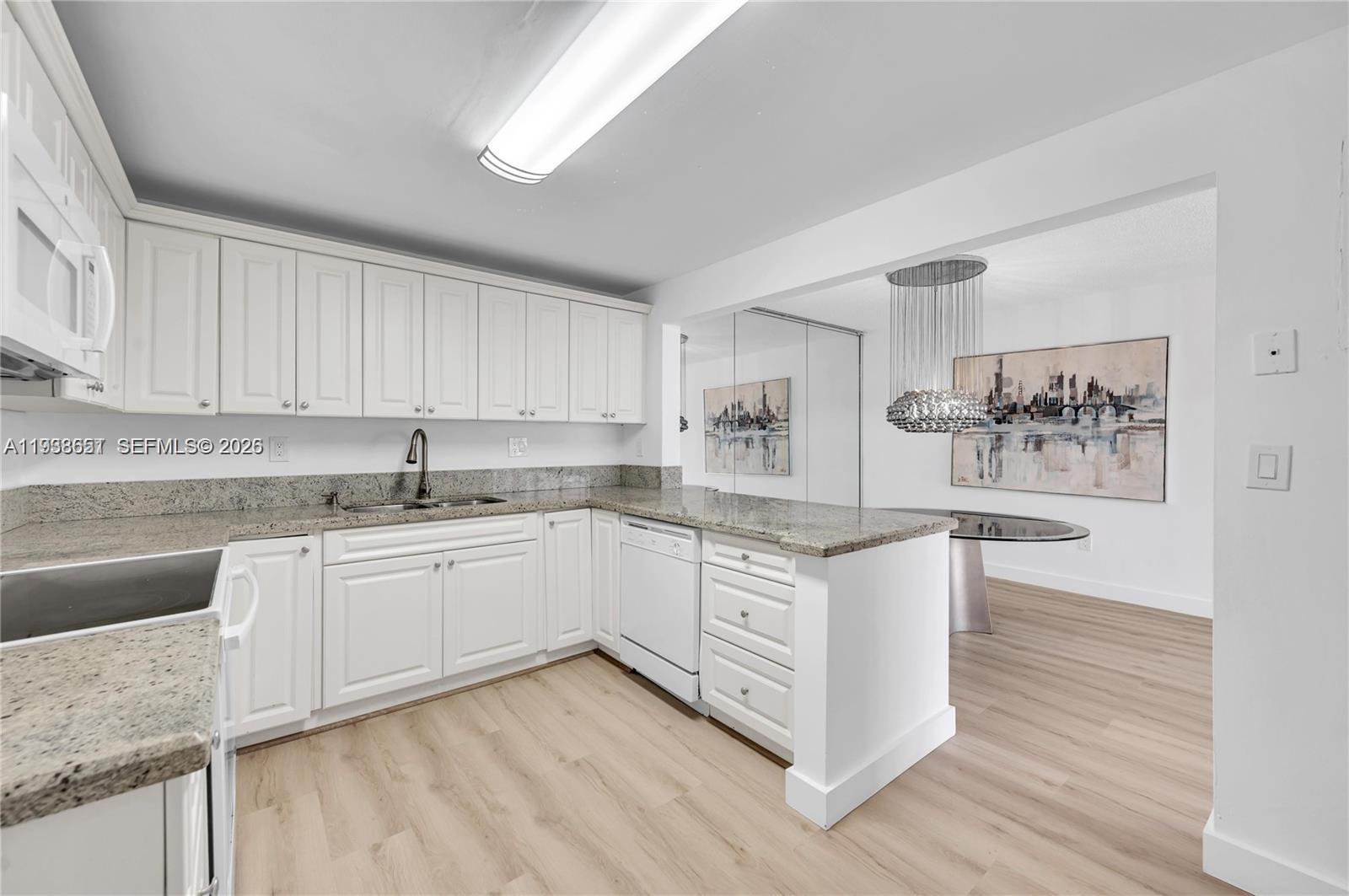6861 Southwest 147th Avenue, Unit 1H Miami, FL 33193 - Photo 12 of 30 a kitchen with stainless steel appliances granite countertop a sink and cabinets