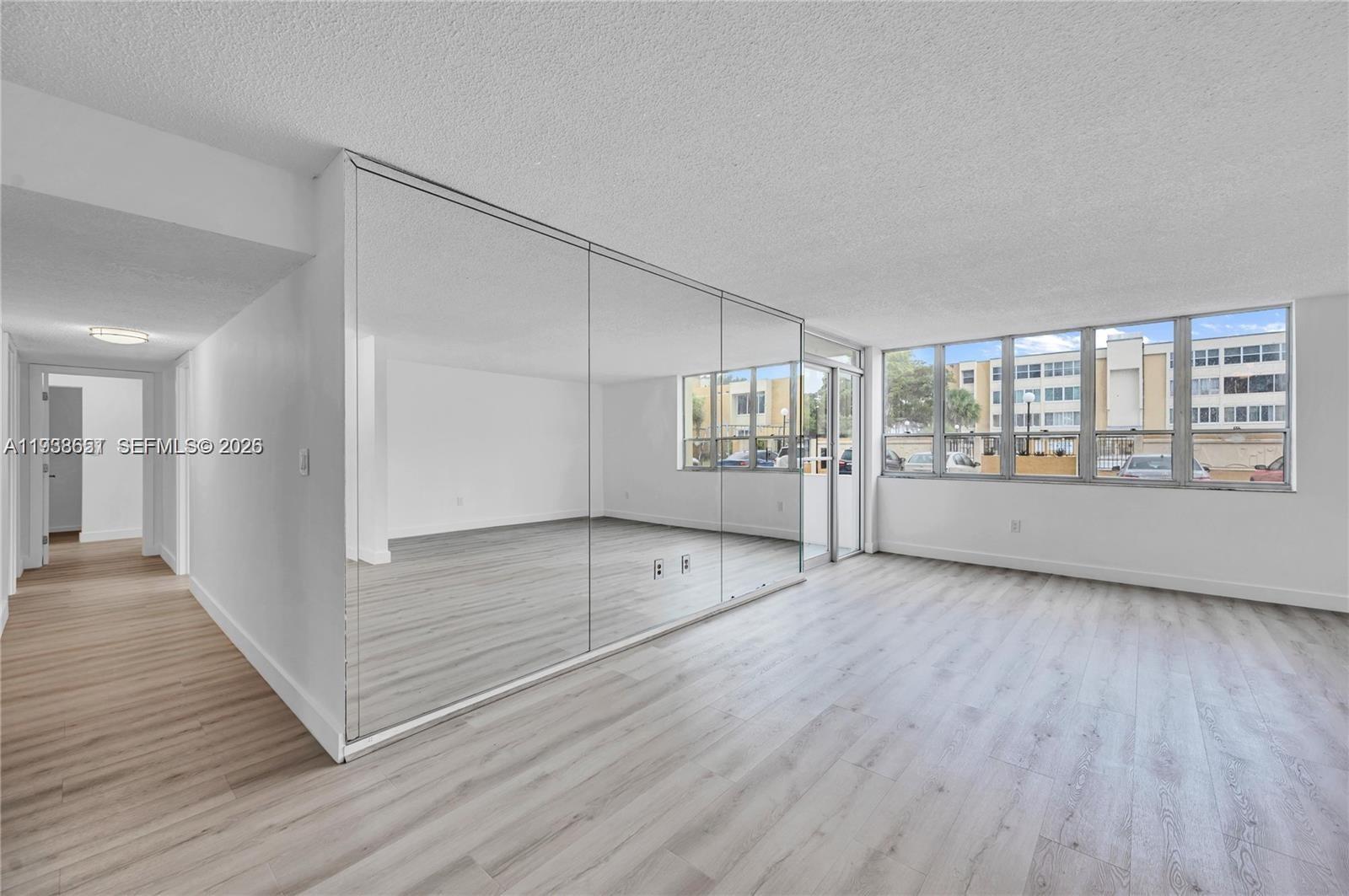 6861 Southwest 147th Avenue, Unit 1H Miami, FL 33193 - Photo 14 of 30 wooden floor in an empty room with a window