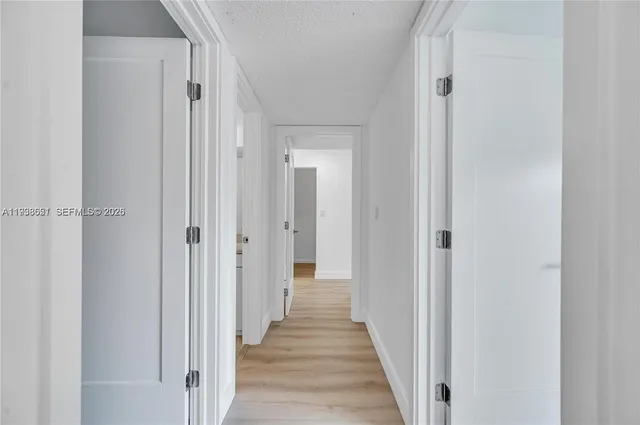a view of a hallway with a wooden door