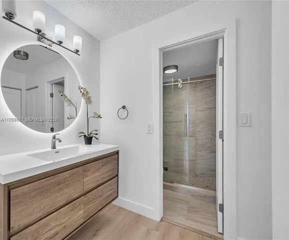 a bathroom with a double vanity sink mirror and shower