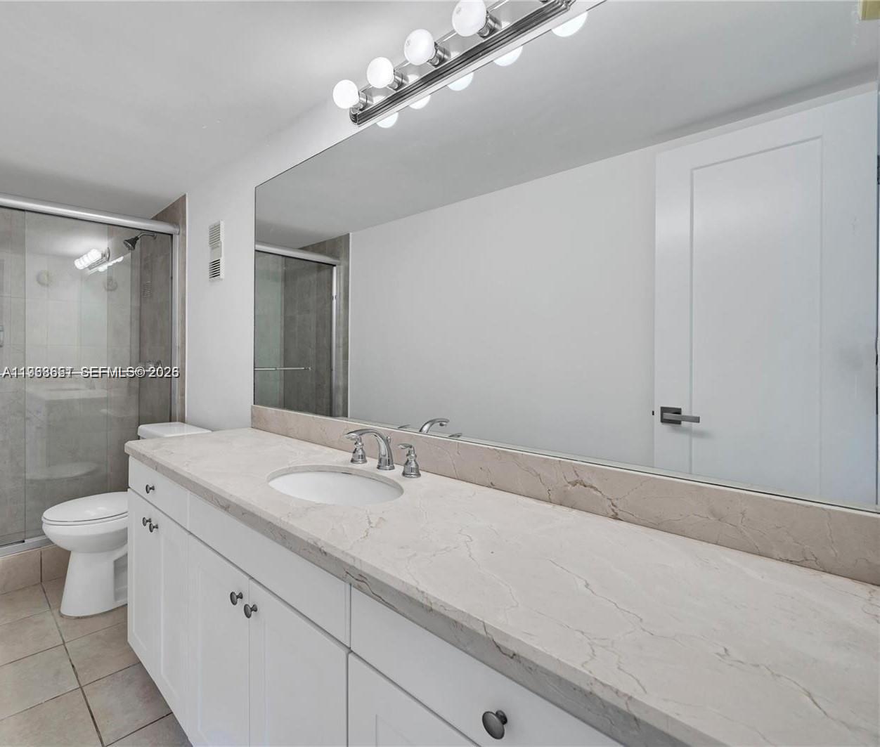 6861 Southwest 147th Avenue, Unit 1H Miami, FL 33193 - Photo 23 of 30 a bathroom with a sink a toilet and shower