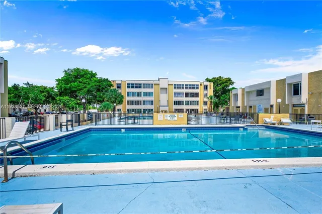 a view of a swimming pool with outdoor seating and plants