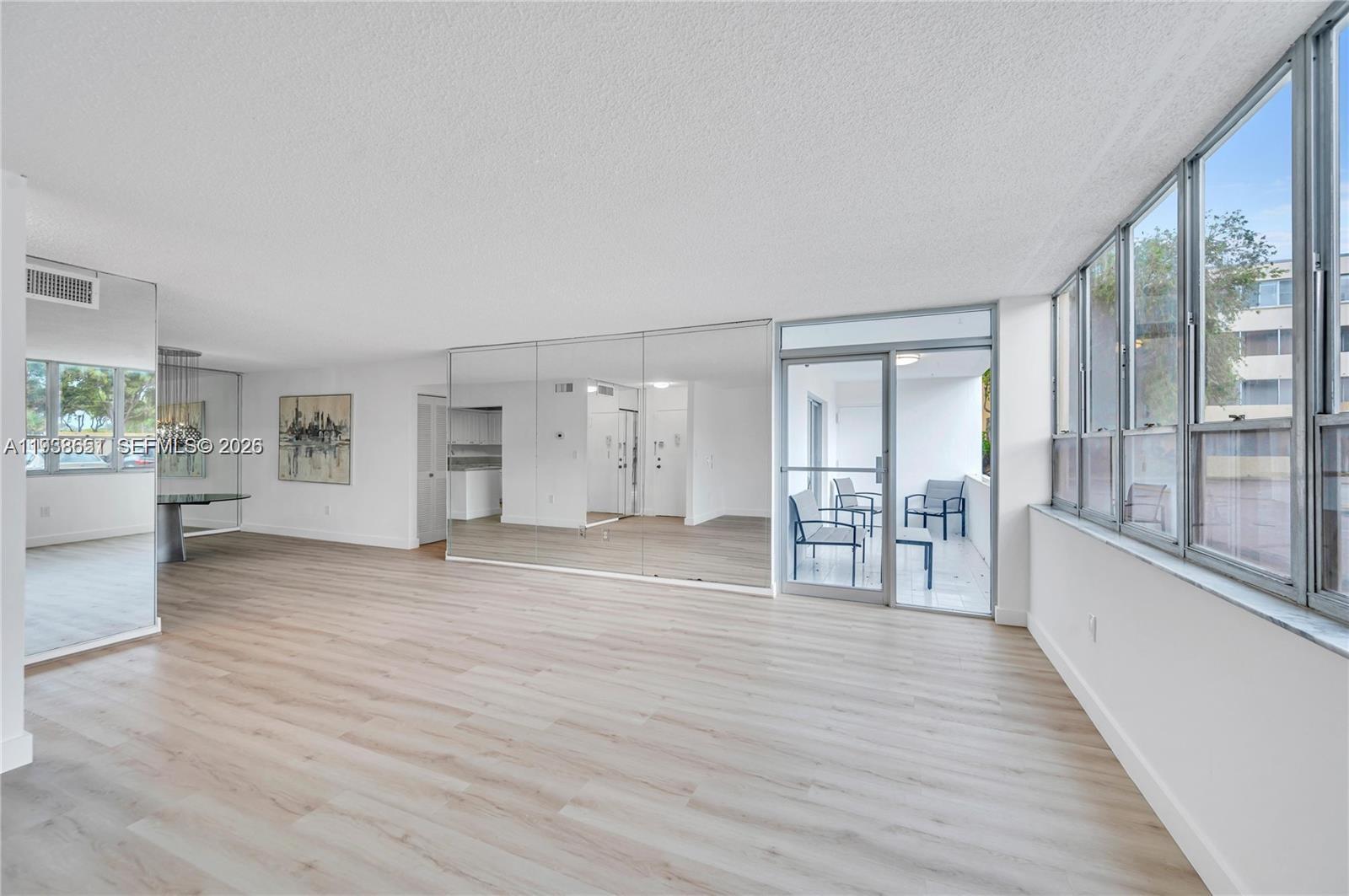6861 Southwest 147th Avenue, Unit 1H Miami, FL 33193 - Photo 10 of 30 wooden floor in an empty room with a window