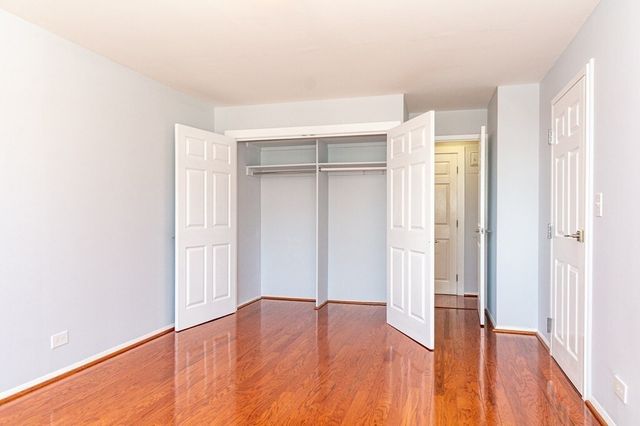 a view of empty room with wooden floor and entryway