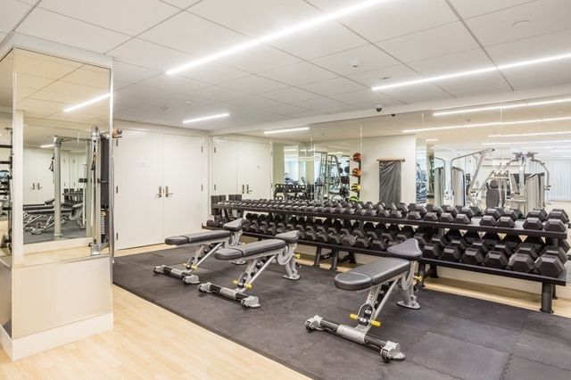 a room with gym equipment and large mirror